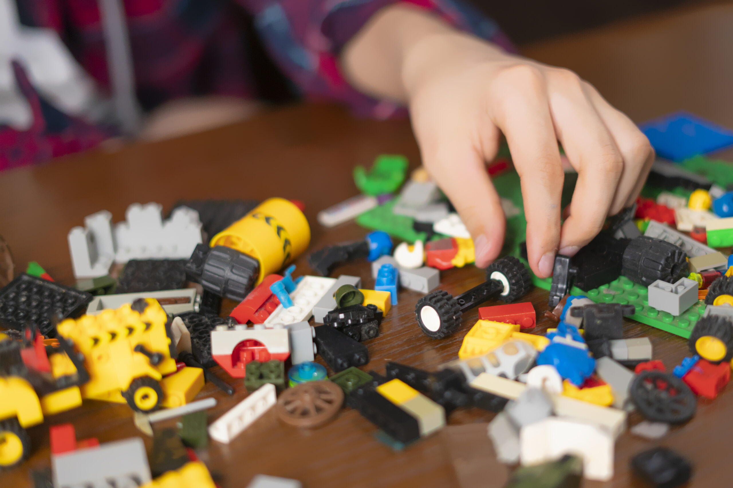 male hands search suitable toy block on wooden table b